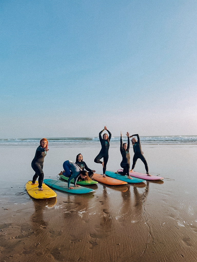 surf yoga retreat marokko alice girls surfbrett colorful yogaposes